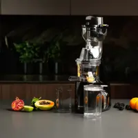 Samcook NutriFlow Slow Juicer i hvit på kjøkkenbenk med fersk grønn juice